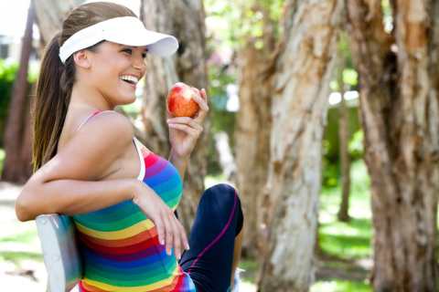 A girl eating an apple in a park